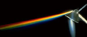 A beam of white light (entering upwards from the right) is dispersed into its constituent colors by its passage through a prism. The fainter beam of white light exiting to the upper right has been reflected (without dispersion) off the first 